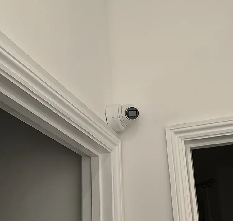 Discreet indoor CCTV camera installed in hallway corner between doorways at residential property in Lambeth, South London
