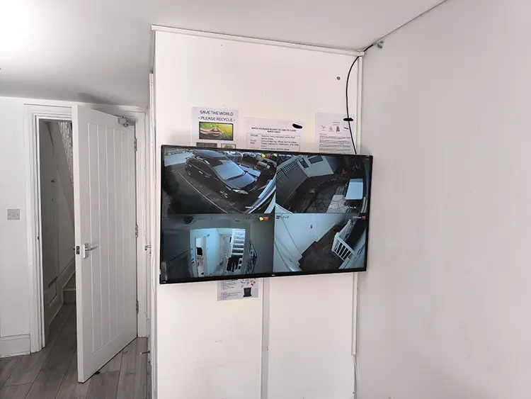 CCTV monitor showing 4-channel live camera feed installed in hallway of residential property in Dulwich SE22