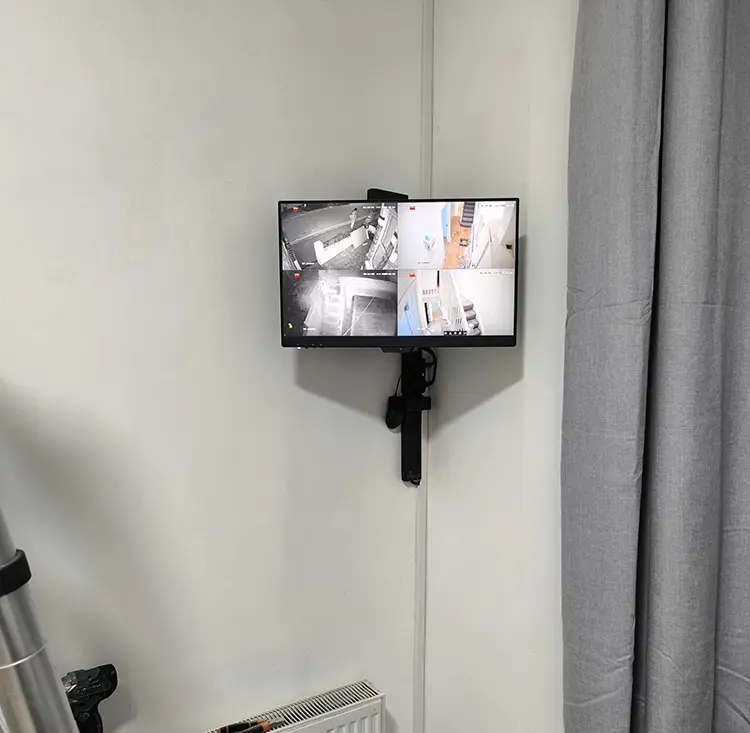 Wall-mounted CCTV monitor showing 4-channel live feed at residential property in Furzedown SW17