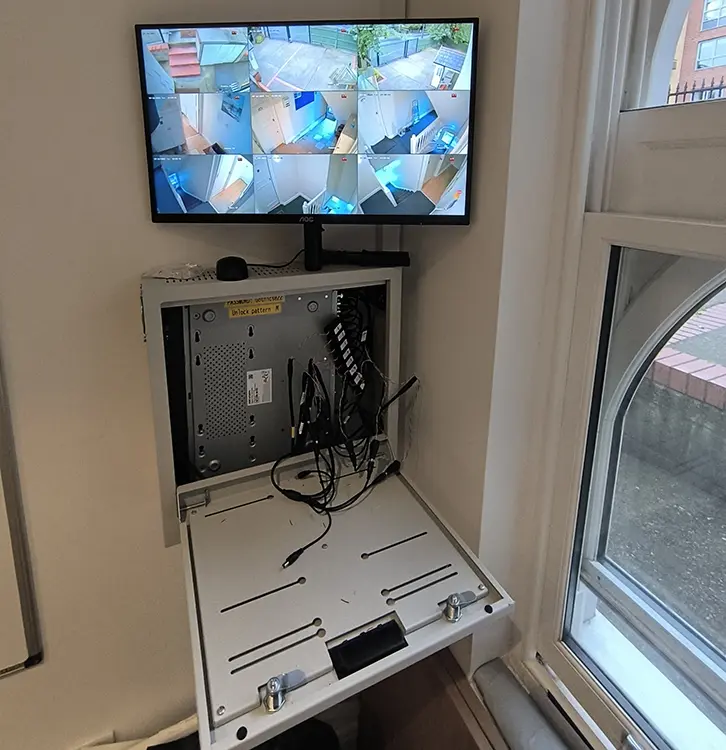 Commercial CCTV 9-channel live view on AOC monitor with DVR cabinet at business premises in Dulwich SE22