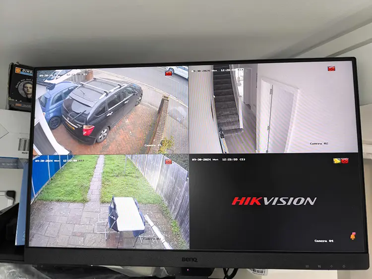 Hikvision 4-channel CCTV monitor displaying live camera feeds including driveway and garden at residential property in Tooting SW17