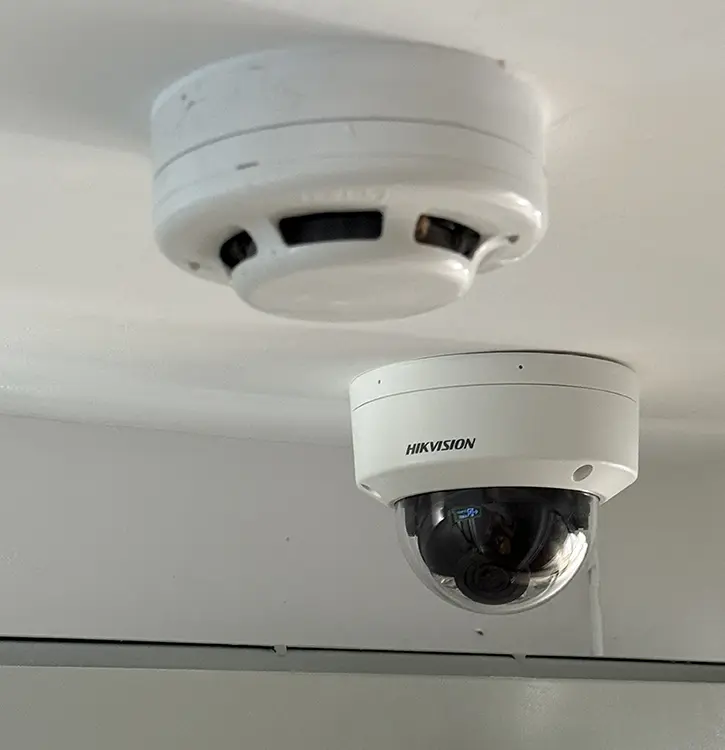 Hikvision dome CCTV camera installed on ceiling alongside smoke detector in Surbiton KT6