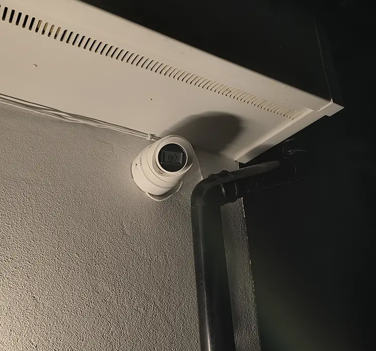 Outdoor CCTV camera installed on exterior garage wall under roof overhang in Furzedown SW16