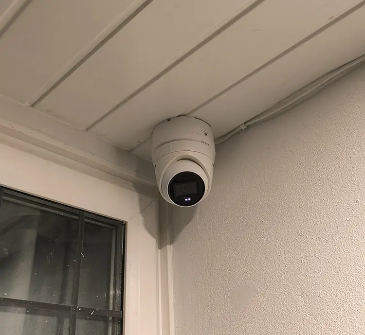 Outdoor dome CCTV camera installed under eave corner of residential property in Furzedown SW16