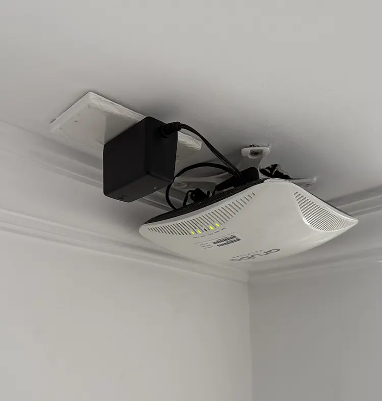Wireless PTZ CCTV camera and router installed on ceiling in Cheam SM3